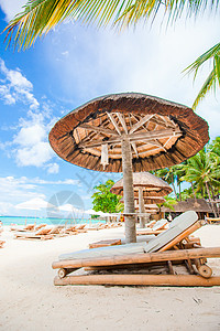 热带热带白色沙沙滩上奇特的海滩床和雨伞奢华情调海洋天堂异国棕榈休息室椅子海岸假期图片