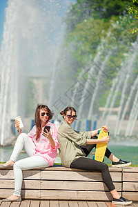 欧洲城市快乐的城市少女的肖像 高加索旅游者在大喷泉前 用滑板露天游览图片