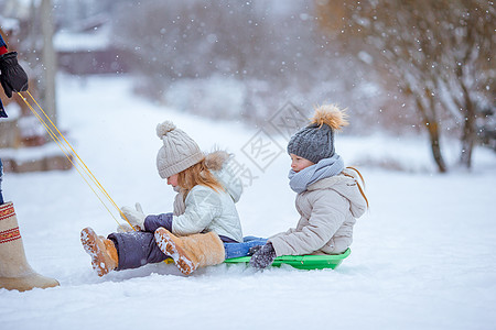 父亲和孩子的家人在圣诞节前夕户外度假游戏天气围巾童年手套雪花骑术女孩乐趣闲暇图片