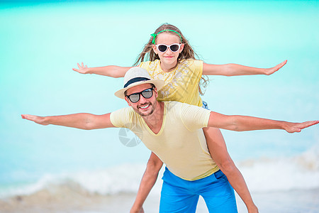 小女孩和快乐的爸爸 在沙滩度假期间玩得开心微笑海岸线成人海洋异国热带幸福童年乐趣父亲图片