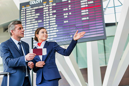 与有吸引力的机场工作人员一起出示登机证的成熟商务人士旅行游客移民乘客会议飞机场男人护照商业电子图片