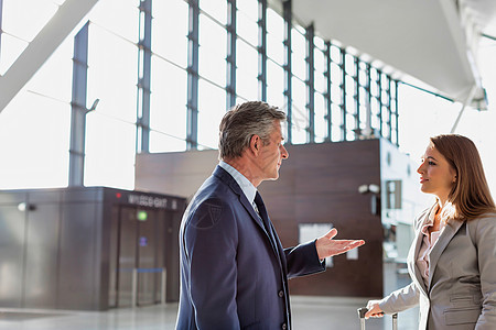 商务人士在机场与商业伙伴讨论计划女士企业家商务电话办公室行李男人游客商界女性背景图片