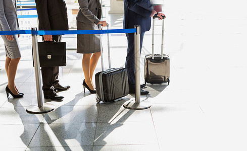 商业人士排队在机场办理报到手续商务女士商界手提箱乘客行李男人飞机场女性会议图片