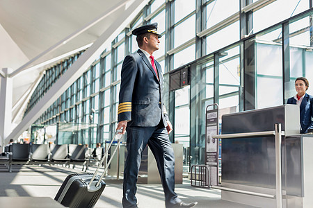 驾驶员在机场登机门上步行进入飞机的成熟飞行员航班护照男人旅行飞机场手提箱国际航空公司工人黄色图片