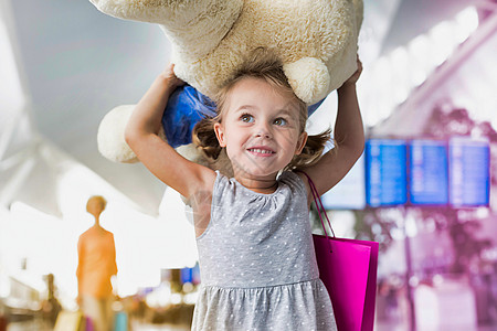 可爱小女孩的肖像 带着她的大泰迪熊 在机场携带黄色闪光照明弹图片