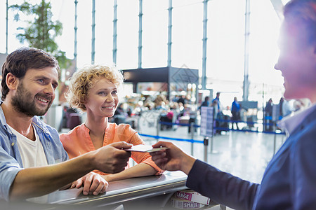 向客运服务人员发放护照 使其在机场获得登机证的男子肖像旅行木板微笑母亲女朋友妻子代理人飞机场工作乘客图片