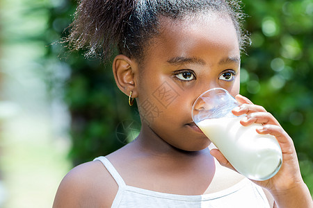 小非洲女孩在户外喝牛奶图片