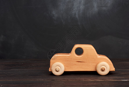 古老的木木童玩具玩具车 黑色背黑格上轮子背景图片