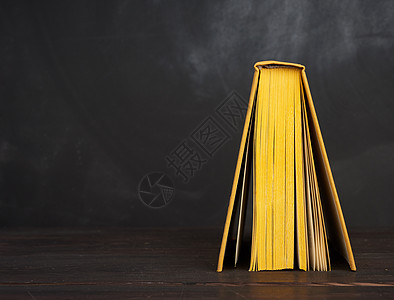 以黄色硬覆盖打开书 与黑粉板相对图片