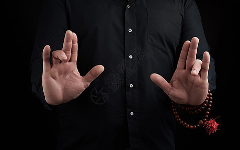 一只成年男子的手在黑暗背景上展示泥巴佛教徒咒语成人拇指手腕男人头脑男性力量精神图片