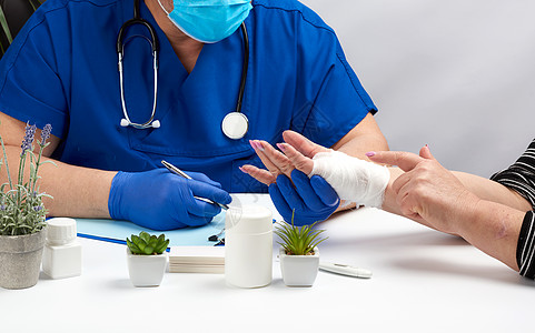 穿蓝乳胶的外伤医生 医疗手套坐在一张标签上图片