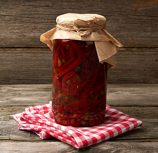 装有泡菜的玻璃罐子 在木头b上卷起红色辣椒胡椒食物水果香料美食燃烧蔬菜烹饪桌子装罐工作室图片