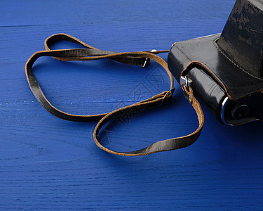 一个木制蓝背面的 皮衣箱中的旧胶片摄像头技术棕色案件照片古董木板桌子镜片乐器绳索图片