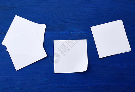 蓝色木质背景上的空白纸文档商业白色贴纸小样黑色框架笔记办公室边缘图片