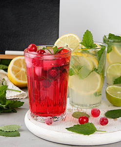 蔓越莓水果喝草莓和红莓的清凉夏日饮料 随心所欲地茶点食物玻璃叶子液体水果热带草本植物桌子薄荷背景