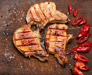 肋骨上的猪肉炒牛排 躺在古老的棕色木板上蔬菜桌子辣椒砧板食物营养午餐烹饪猪肉美食图片