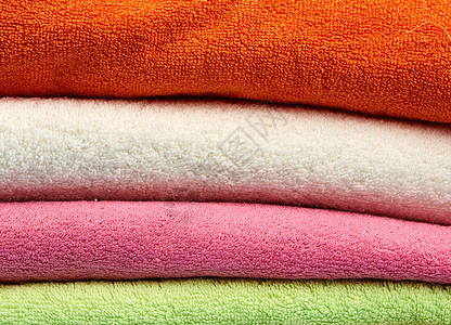 一堆彩色棉毛巾折叠毛巾洗衣店橙子身体海绵卫生棉布家庭织物按摩治疗图片