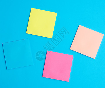 蓝色上不同颜色的多彩白纸纸贴纸正方形床单软垫办公室笔记记忆别针黄色空白绿色图片