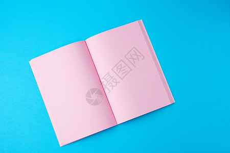 打开的笔记本 上vi 蓝色背景上的粉色页面为空白图片