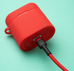 在连接电缆的红色箱子中装有耳机充电器的框力量绳索适配器电脑电池充值技术活力绿色金属图片