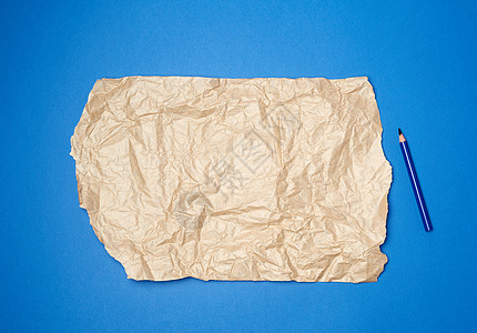一张棕色皱巴巴的纸 用于深蓝色背面的包装图片