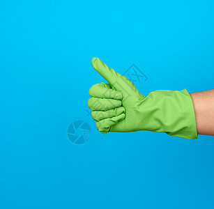 戴着绿色防护橡胶手套的手表现出像蓝色的手势图片