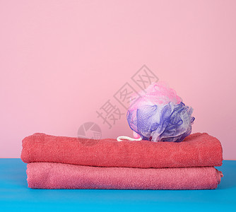 粉色折叠毛巾和一块塑料毛巾图片