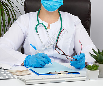 穿白外套的年轻女青年医生 无菌医学手套写作蓝色记事本医院工作职业访问护士文档保健女性图片
