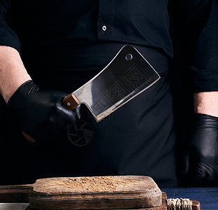 穿黑色制服和黑乳胶的男性烹饪者戴着大手套职业餐厅工具棕色木头食物男人桌子厨房木板图片