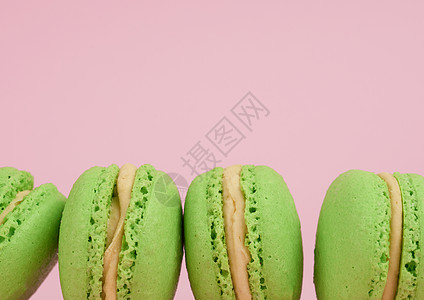 绿色圆环烤马卡龙面粉红色背景的麦子 Delici图片