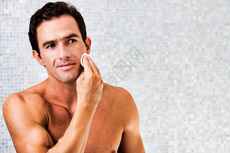 在浴室里用棉花和墨粉擦脸的 年轻有吸引力的男人的肖像商业碳粉卫生洗手间白色清洁护理皮肤胡须泡沫图片