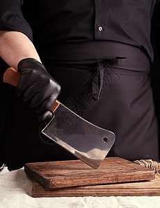 穿黑色制服和黑乳胶的男性烹饪者戴着大手套厨师工作室男人工作厨房木头美食食物餐厅桌子图片