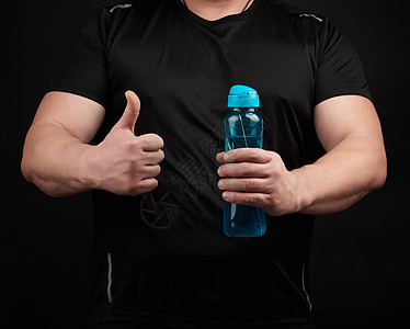 肌肉有肌肉的成年男性运动员有一个塑料水瓶 Wi图片