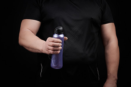 肌肉有肌肉的成年男性运动员持有塑料水瓶黑色手臂茶点液体饮料食物运动装工作室成人身体图片