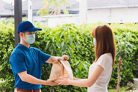 青年男子提供快餐纸袋的快餐 t疾病女士邮递员男性服务商业运输送货导游食物图片