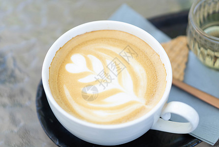 拿铁咖啡艺术以木本底的咖啡郁金香形状 加热杯拿铁艺术乡村牛奶玻璃杯子背景