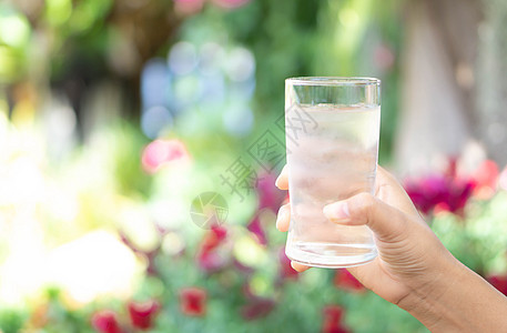 紧紧的女士手握着一杯纯净的水 以便她与众人交接反射手指绿色玻璃手臂白色女性手势液体背景图片