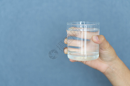 紧紧的女士手握着一杯纯净的水 以便她与众人交接手势玻璃白色反射液体女性手臂手指背景图片