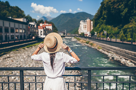 快乐的姑娘 在山河堤边 在欧洲城市里假期房子旅行爬坡女士旅游帽子女孩晴天游客图片