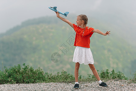 美丽的快乐小女孩 在大雾的深雾中山上天空玩具孩子顶峰闲暇天气幸福缆车空气和平图片