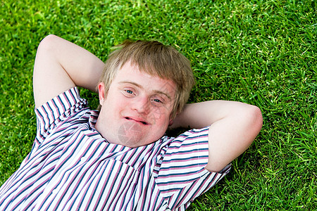 残疾男孩在绿草上放松图片