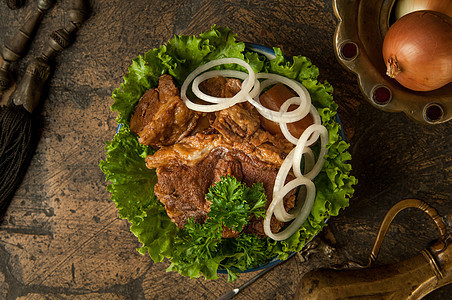 在一个古老的铺石上的肉盘沙拉鹅卵石美食古董辫子水壶盘子石头陶器棕色图片