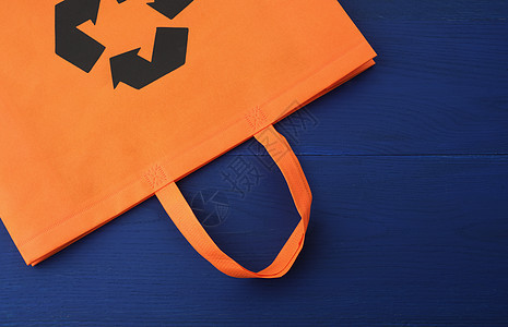 蓝色木质背景上可重复使用的橙色粘胶袋材料木板手提包纺织品生态回收帆布环境顾客店铺图片