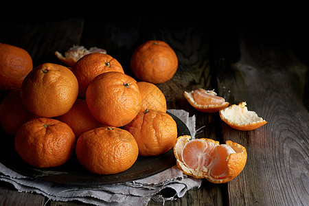 一大堆未穿过的圆圆熟橙橘色芒达林 在灰亚麻布小便袋上营养橙子小吃果汁水果食物热带餐巾木头桌子图片