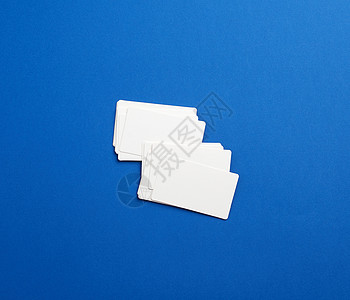 蓝色背景上的一叠长方形白色空白名片推广地址推介会职业公司卡片小样办公室品牌身份图片
