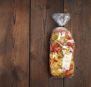 以o为单位的含有原始多彩意面的透明纤维素袋玻璃纸小麦美食食物糖类黄色午餐烹饪营养领带图片