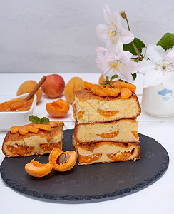 黑石墨板上的杏桃派正方形片水果烹饪早餐食物糕点海绵橙子小吃营养面包图片