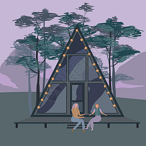 两个女人靠近一个框架的小房子 它制作图案在树林里的小屋图片