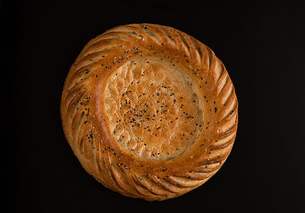 黑暗背景上的面包圆形种子粮食烘烤宏观食物小麦芝麻椭圆形面粉背景图片