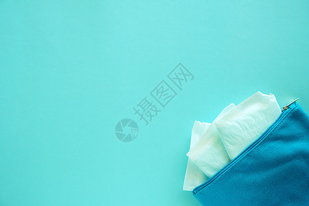 蓝色背景妇女织布袋中的卫生巾纸卫生女士洗手间钱包保健旅行棉布药品配饰餐巾图片